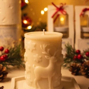 Vela Alce Navideño: vela cilíndrica de cera vegetal con relieve de alce y copos de nieve Blue Dragonfly